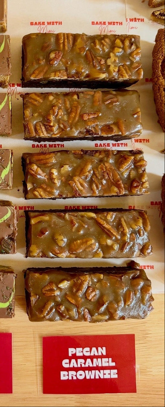 Pecan caramel brownies topped with pecans on Bake With Mimi bakery display