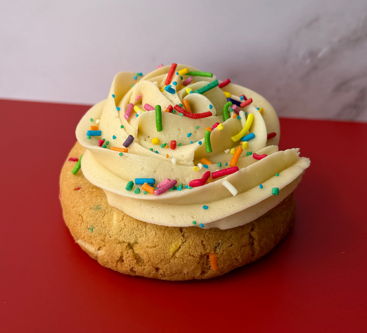 Funfetti cookie with vanilla frosting and colorful sprinkles on red background, Bake With Mimi