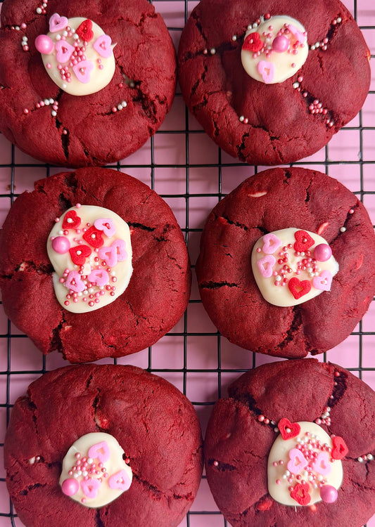Red velvet cookies with white chocolate and heart sprinkles on cooling rack, Bake With Mimi